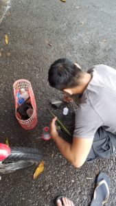 Vietnamese man repairing a flip flop on the street