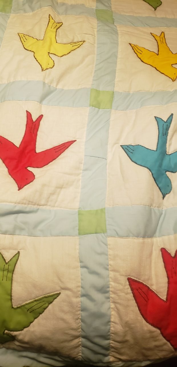 part of a quilt with birds of different colors